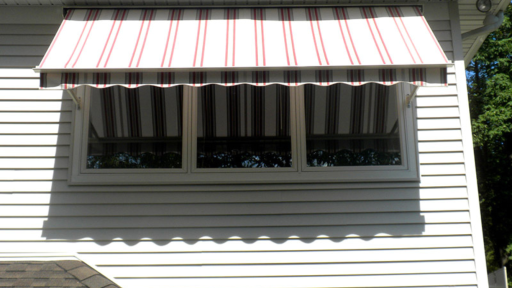 A house window with a red and white striped novita awning