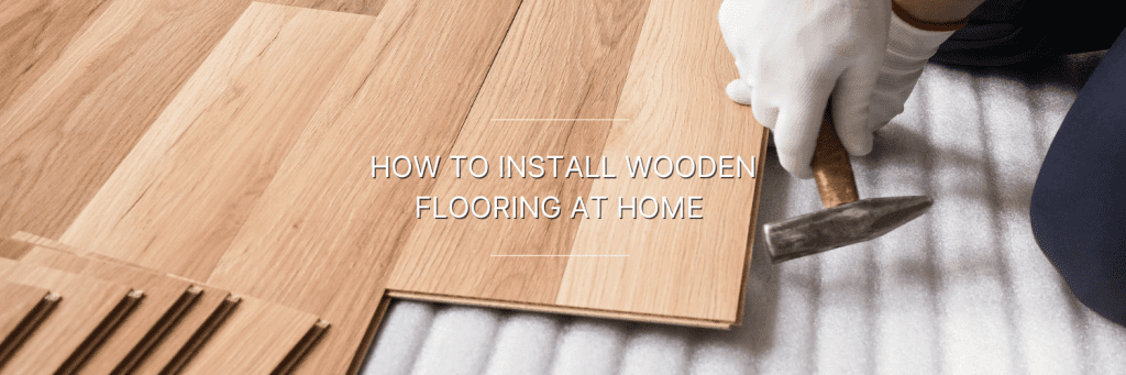 A person installing wooden flooring in home