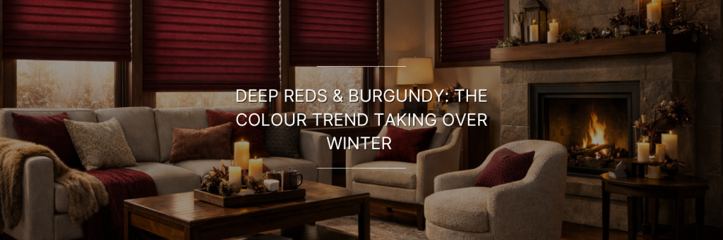 Cozy winter living room featuring deep red and burgundy decor, a stone fireplace, and warm lighting for a inviting atmosphere.