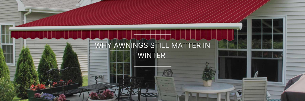 A home patio with a red awning, surrounded by greenery and outdoor furniture, highlighting the importance of awnings in winter.