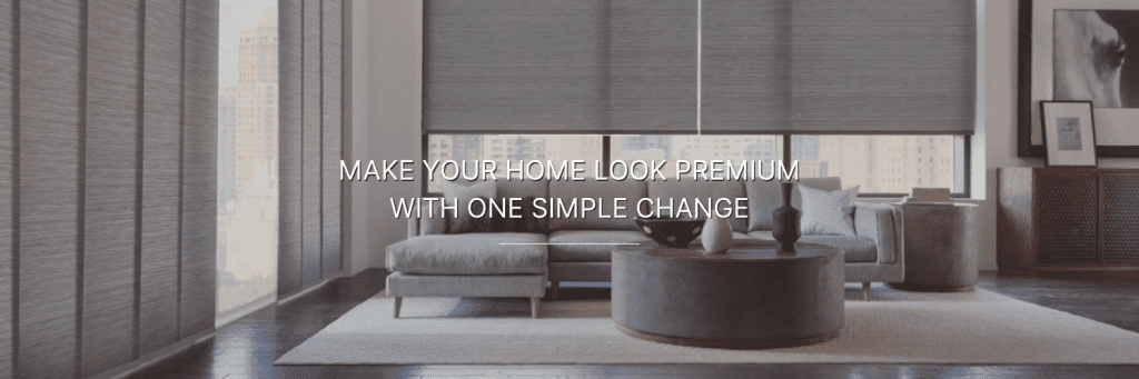 Sophisticated living room with sleek blinds, modern gray sofa, and round coffee table. Text reads, "Make your home look premium with one simple change."