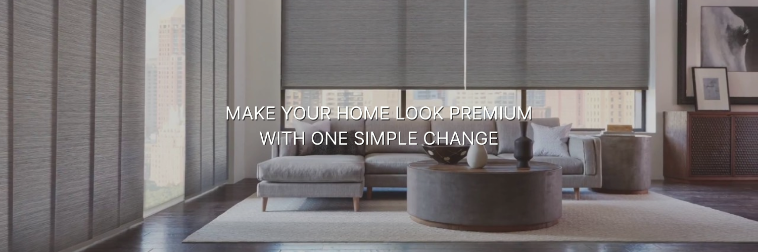 Sophisticated living room with sleek blinds, modern gray sofa, and round coffee table. Text reads, "Make your home look premium with one simple change."