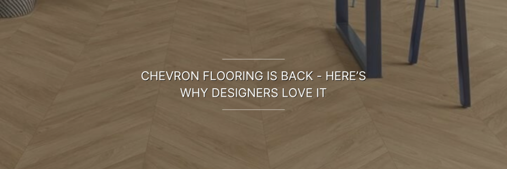 Chevron-patterned wooden flooring with a modern, stylish look. A navy chair leg is visible, adding a touch of sophistication. Text reads: "Chevron flooring is back – here’s why designers love it."
