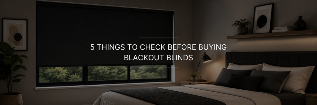 Cozy bedroom with a large charcoal blackout roller blind covering a wide window.