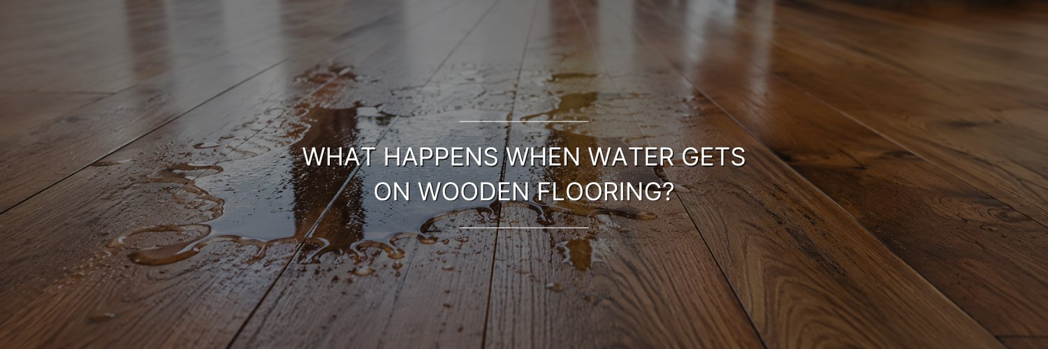 Wooden floor with a large water spill and scattered droplets.