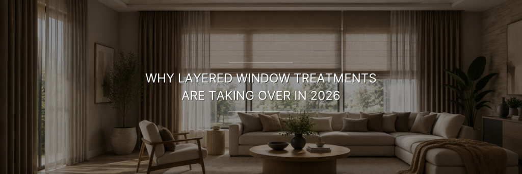 Elegant living room with layered curtains and Roman shades covering large windows.